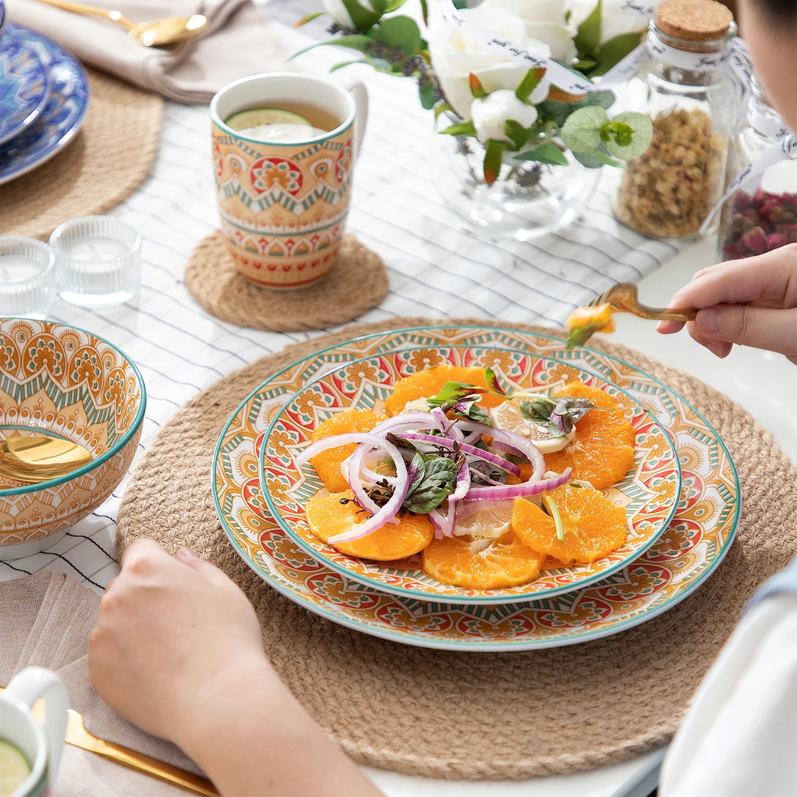Bohemian dinnerware set on a dining table with colorful salad, showcasing mandala pattern plates and ceramic bowl.